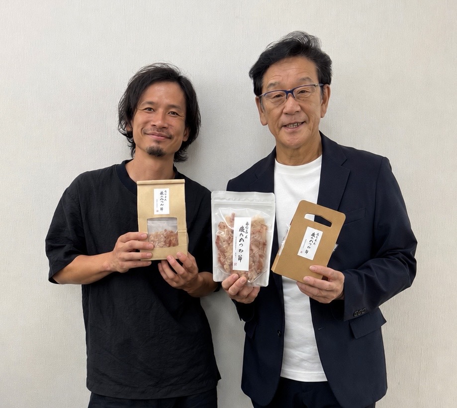 金七商店の商品を手に笑顔で並ぶ家族